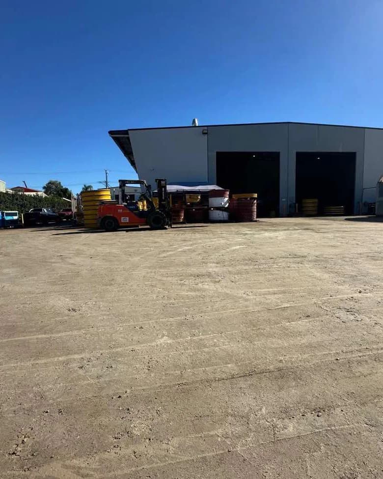 Stacked product and stored plant on a level, bound laydown area